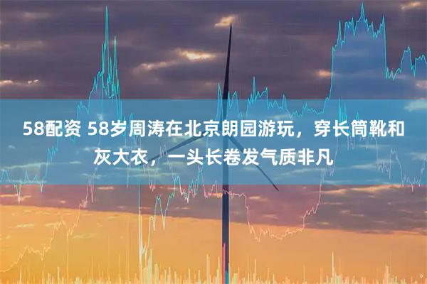 58配资 58岁周涛在北京朗园游玩，穿长筒靴和灰大衣，一头长卷发气质非凡